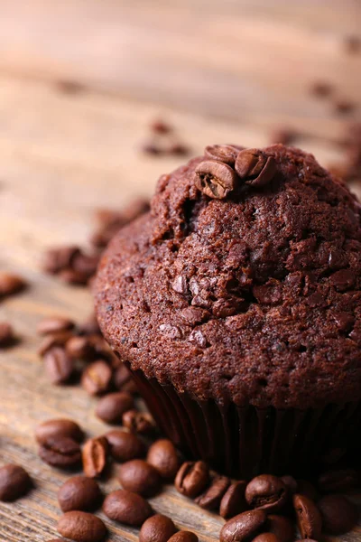 Choklad muffin och kaffe korn på trä bakgrund — Stockfoto