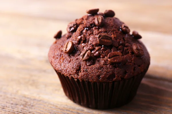 Čokoládový muffin a kávové zrna na dřevěné pozadí — Stock fotografie