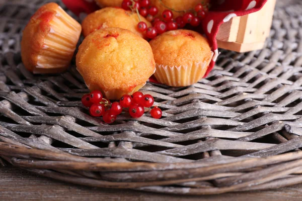 Hasır mat zemin üzerine kırmızı kuş üzümü ile lezzetli muffins — Stok fotoğraf