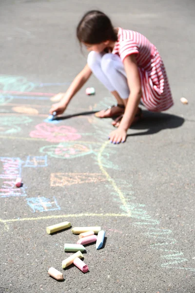 Cute girl drawing with chalk on asphalt — Stock Photo, Image