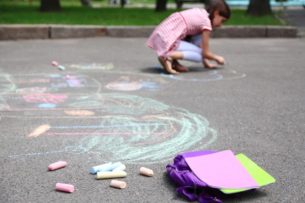 Cute girl drawing with chalk on asphalt — Stock Photo, Image