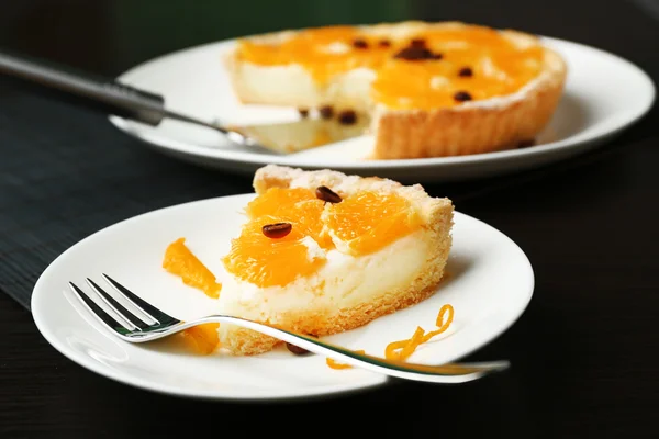 Pedaço de torta de laranja caseira na placa, na cor de fundo de madeira — Fotografia de Stock