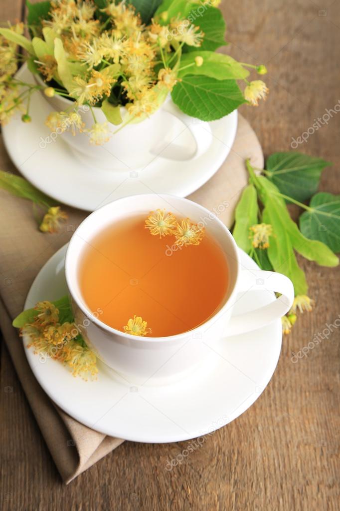 Tasty herbal tea with linden flowers on wooden table