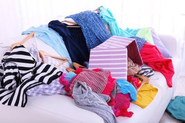 Messy colorful clothing on  sofa clipart