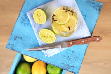 Taze yaz içeceği, limonlu ve camlı karanfiller, renkli ahşap masa, açık arkaplan