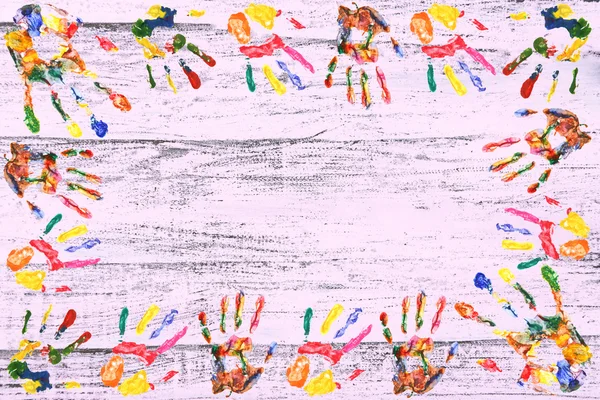 Рамка кольорового друку рук на дерев'яному фоні — стокове фото