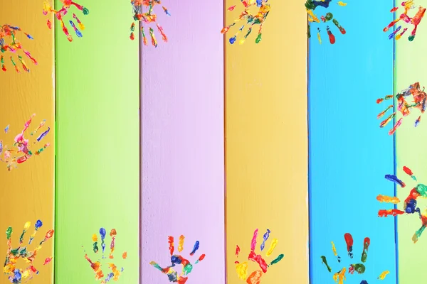 Frame of color hands print on wooden background — Stock Photo, Image