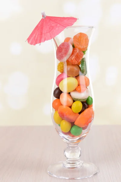 Diferentes dulces de frutas de colores en vidrio en la mesa sobre fondo claro — Foto de Stock