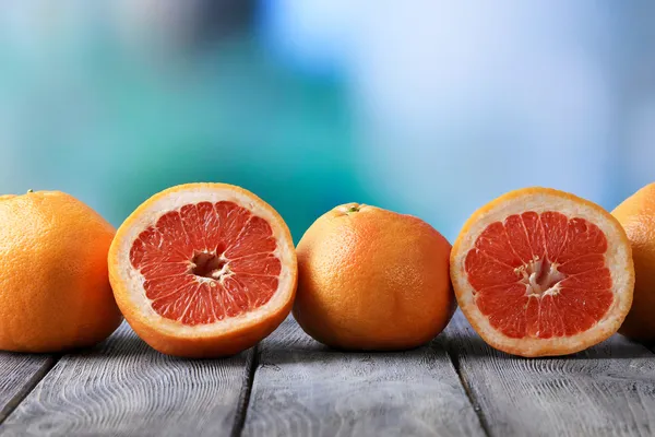 Ripe grapefruits on wooden board, on bright background — Stock Photo, Image