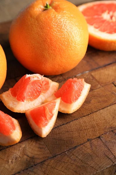 Ripe grapefruits on cutting board, on wooden background — Stock Photo, Image