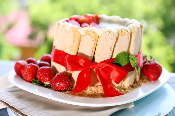 Leckere Torte Charlotte mit frischen Erdbeeren auf grünem Naturhintergrund — Stockfoto