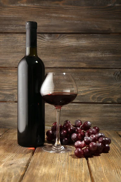 Μπουκάλια κρασί με γυαλί σε ξύλινα φόντο — Φωτογραφία Αρχείου