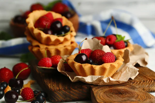 Tasty tartlets dengan buah berry di atas meja kayu — Stok Foto