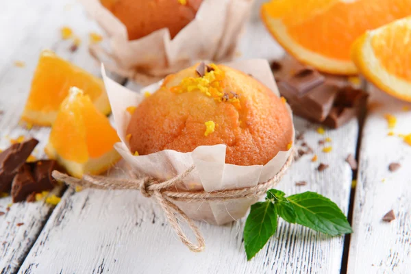 Tasty cupcakes with orange on table close-up — Stock Photo, Image