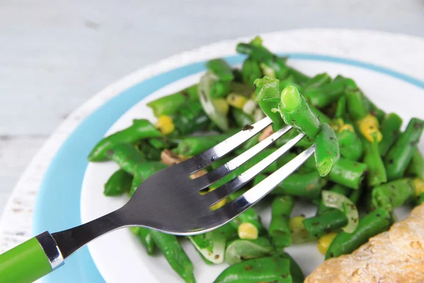 Salade met groene bonen, ham en maïs op plaat, op een houten achtergrond kleur — Stockfoto