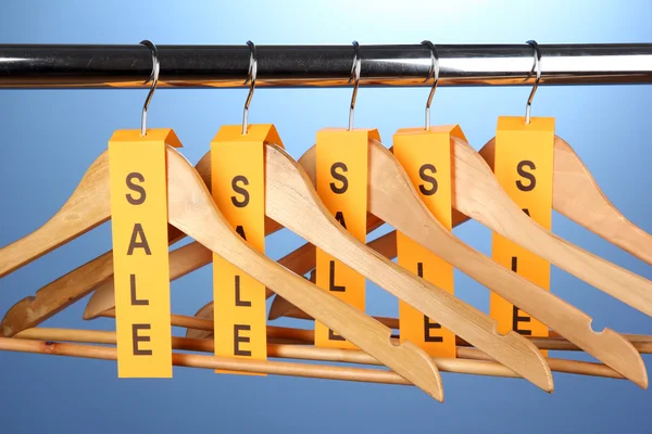 Wooden clothes hangers as sale symbol — Stock Photo, Image