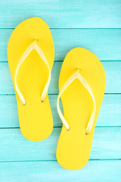 Helle Flip-Flops auf farbigem Holzhintergrund — Stockfoto