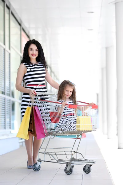 Happy mom and daughter with shop bags, outdoors — Stock Photo, Image