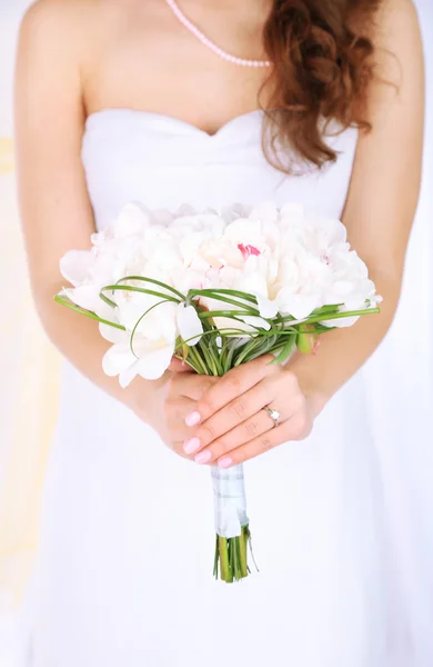 Bruden hålla bröllop bukett vita pioner, närbild, på ljus bakgrund — Stockfoto