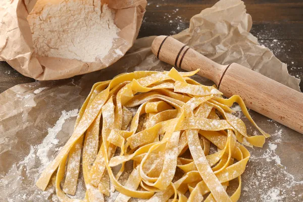 Natura morta con pasta cruda fatta in casa e ingredienti per la pasta — Foto Stock