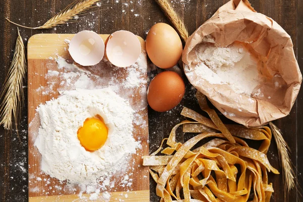 Nature morte avec des pâtes maison crues et des ingrédients pour les pâtes — Photo