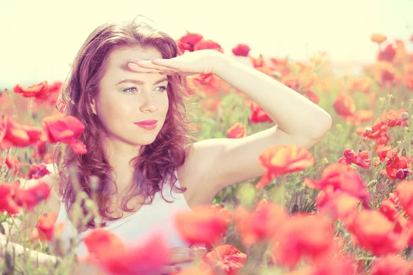 Όμορφη νεαρή γυναίκα στο χωράφι με τις παπαρούνες — Φωτογραφία Αρχείου