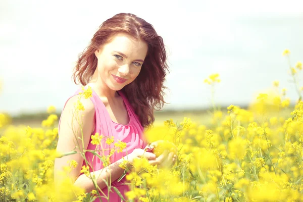 Mooie jonge vrouw met kersen in veld — Stockfoto