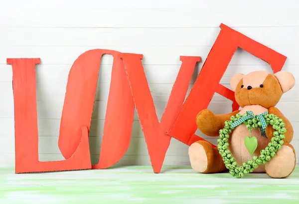 Letras decorativas formando palabra AMOR con oso de peluche — Foto de Stock