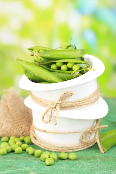 Fresh green peas in bowl on wooden table, outdoors — Stock Photo, Image