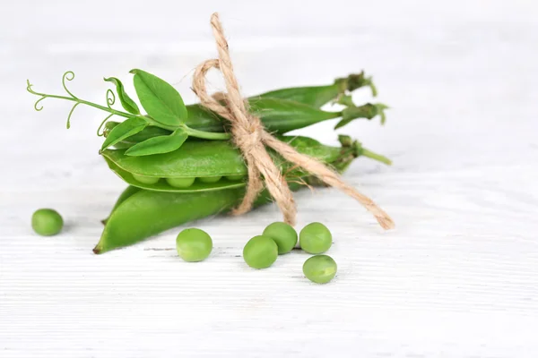 Fresh green peas on wooden table — Stock Photo, Image