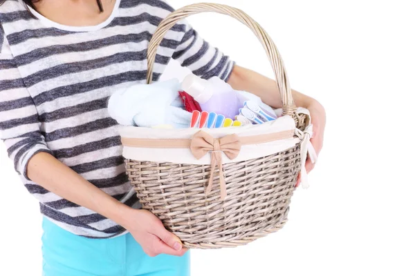 Mulher segurando cesta de lavanderia com roupas limpas, toalhas e pinos, isolado em branco — Fotografia de Stock