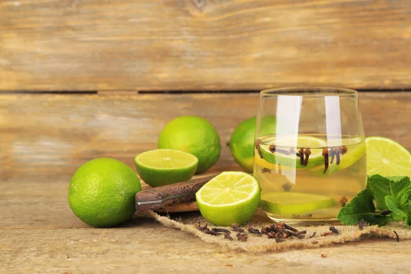 Bebida fresca de verão com limão e cravo em vidro, na cor de fundo de madeira — Fotografia de Stock