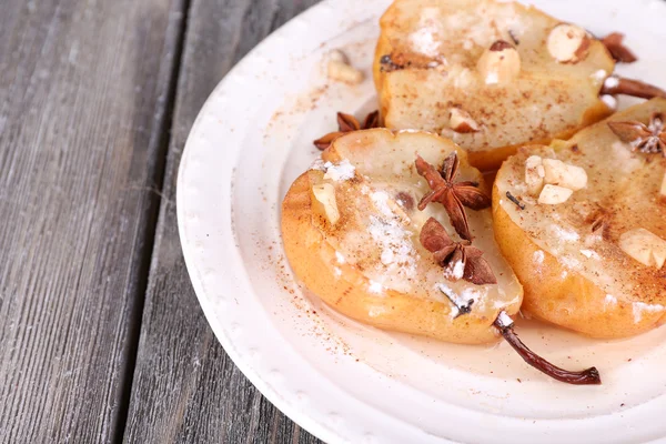 Baked pears with syrup on plate, on color wooden background — Stock Photo, Image