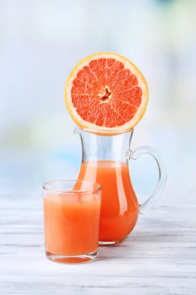 Zumo de pomelo en vaso y jarra sobre fondo de madera de color —  Fotos de Stock