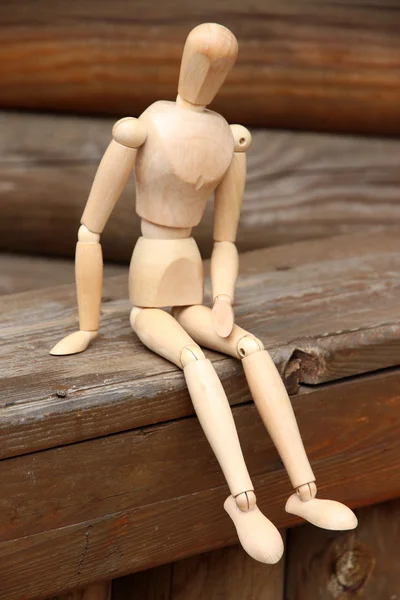 Títere de pose de madera sentado en un banco de madera, al aire libre —  Fotos de Stock