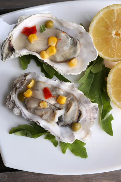 Tasty cooked oysters in shell on wooden table — Stock Photo, Image