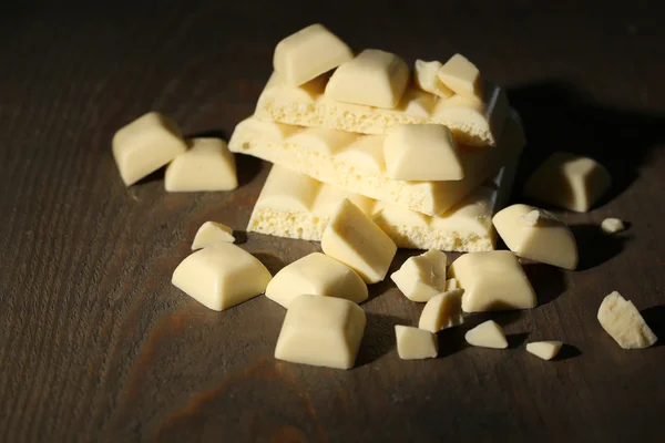 Złamane czekolady na drewniane tła kolor biały — Zdjęcie stockowe