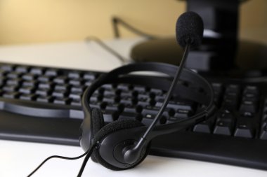 Beyaz Danışma arka plan üzerinde kulaklık ve klavye yakın çekim