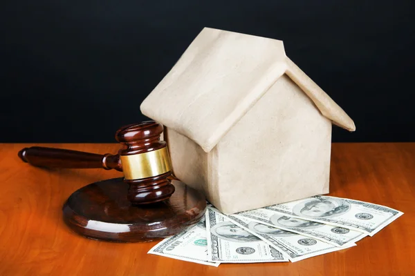 Gavel,model of house and money on table on black background — Stock Photo, Image