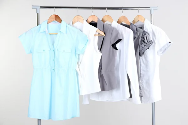 Bürokleidung auf Kleiderbügeln, auf grauem Hintergrund — Stockfoto