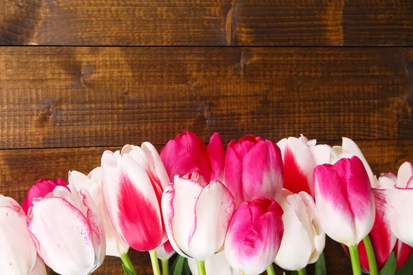 Mooie tulpen op een houten achtergrond kleur — Stockfoto
