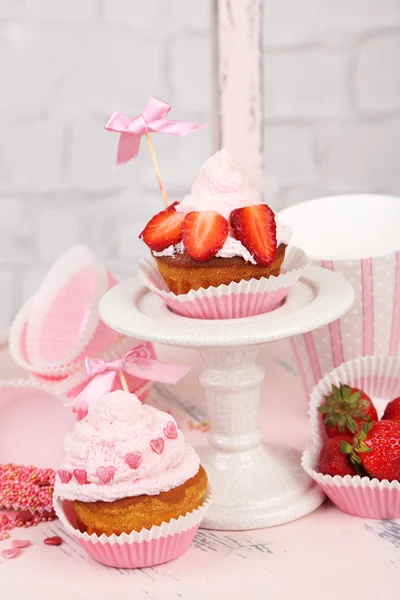 Tasty cup cakes with cream on wooden chair — Stock Photo, Image