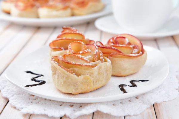 Tasty  puff pastry with apple shaped roses on plate on table close-up — Stock Photo, Image