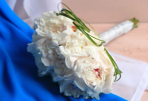 Schöner Hochzeitsstrauß auf farbigem Holzhintergrund — Stockfoto