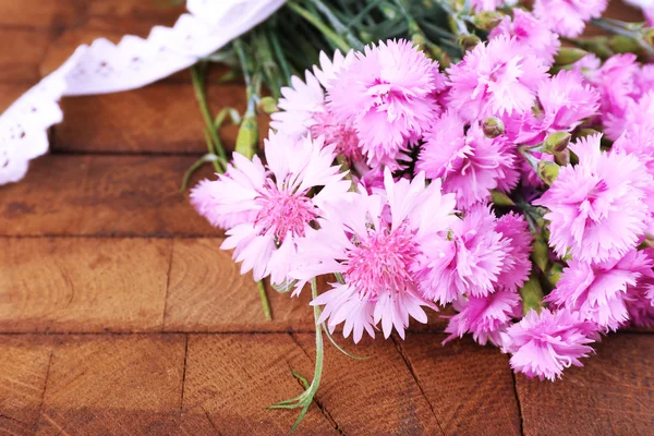 Beau bouquet avec ruban en dentelle sur fond bois — Photo