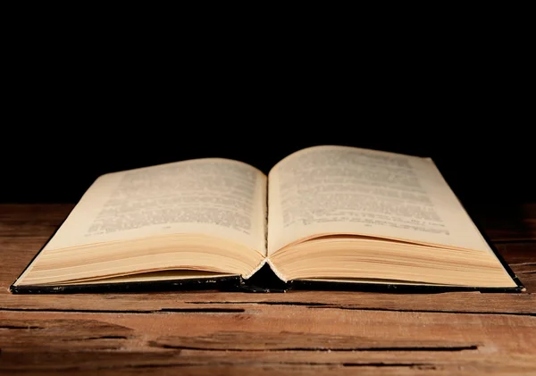 Livro velho na mesa sobre fundo preto — Fotografia de Stock