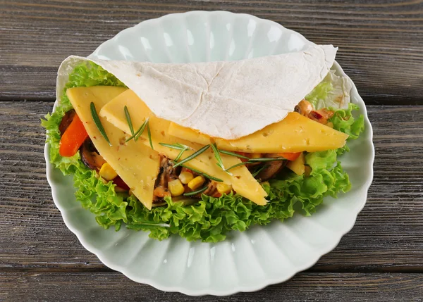 Envoltura vegetal llena de queso y verduras frescas en la mesa —  Fotos de Stock