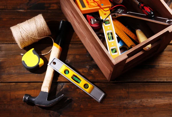 素朴な木製の背景上のさまざまなツールと木製の箱 — ストック写真
