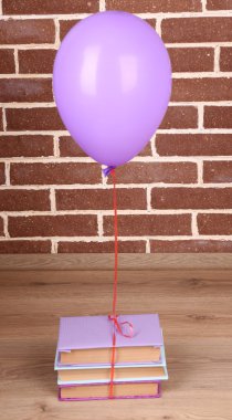 Kitaplar tuğla duvar arka plan üzerinde renkli balon