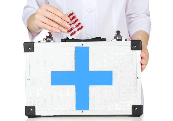 Sjuksköterska hålla första hjälpen kit, isolerad på vit — Stockfoto